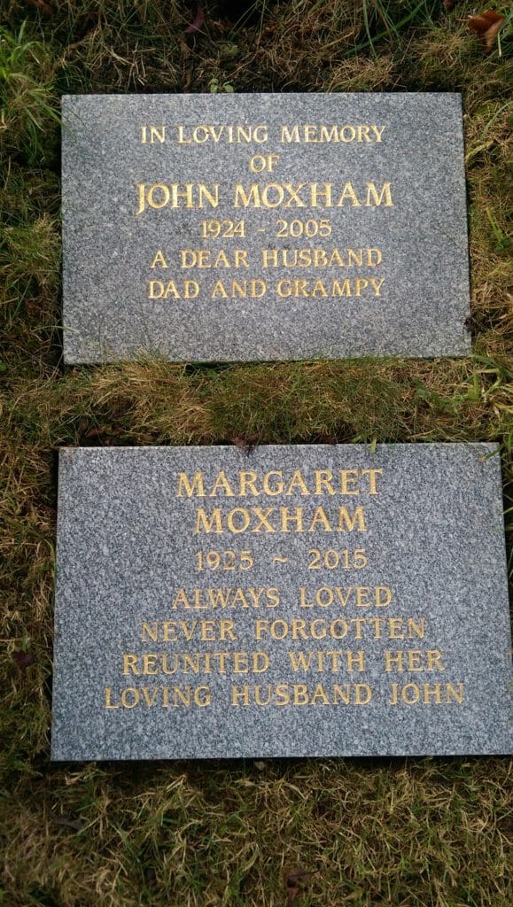 Two gravestones on grass. The first reads, "In loving memory of John Moxham 1924-2005, a dear husband, dad, and grampy." The second reads, "Margaret Moxham 1925-2015, always loved, never forgotten, reunited with her loving husband John.